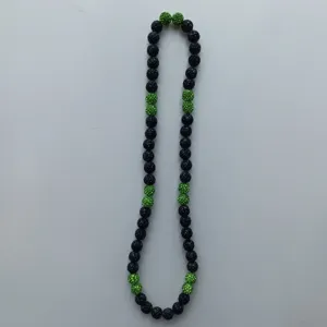 Black and green rhinestone ball necklace detail, sparkling bead fashion jewellery accessory.