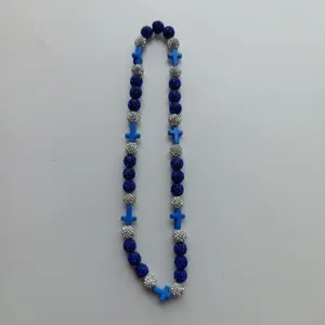 Detailed view of the blue and silver Shamballa rhinestone bead necklace with cross charms.
