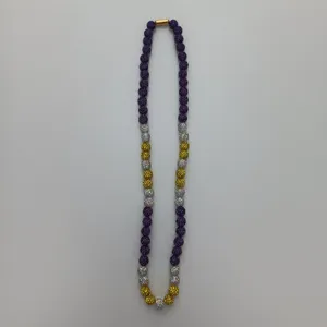 Detail view of a colorful Shamballa style beaded necklace with purple and gold rhinestones.
