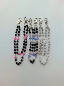 Detail of 12mm clay rhinestone ball waist chains with cross charms in multiple colors.