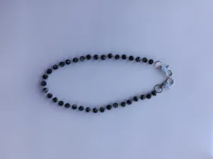 Close-up detail of sparkling black rhinestone shamballa bead chain strap for pants or bags.