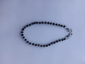 Black rhinestone shamballa bead pants chain detail close up showing sparkling crystal balls and metal clasps.