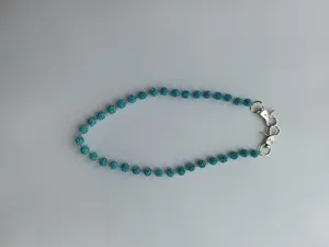 Close up detail view of sparkling blue crystal rhinestone bead chain with silver metal clasps.