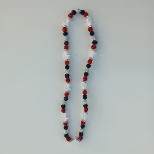 Detailed view of red white and blue rhinestone clay ball and cross beaded necklace.