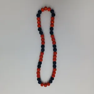 Detailed shot of sparkling rhinestone ball beads necklace, vibrant red and dark blue tones.