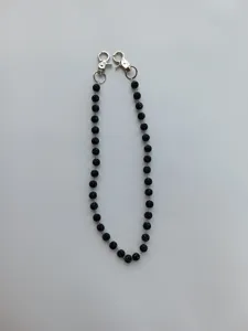 Close-up view of the black crystal pave bead chain featuring sturdy silver lobster clasps.