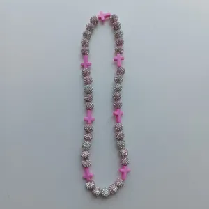 Detailed close-up view of the handmade rhinestone clay bead and pink cross fashion necklace.