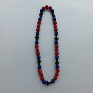 Close-up detail of the red and blue rhinestone shamballa beads necklace with black cross.