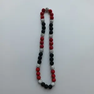 Detail view of colorful red, black and silver rhinestone Shamballa clay beads necklace.