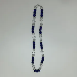 Detailed view of blue and silver rhinestone disco ball necklace with white cross beads for women.