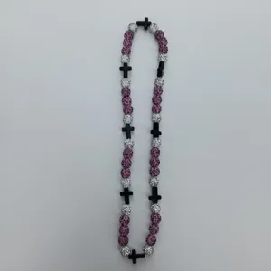 Detail view of the beaded necklace featuring pink and silver rhinestone balls with black cross accents.