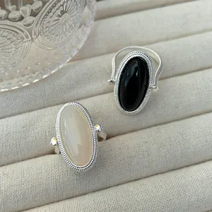 Close-up of reversible silver wire wrapped rings with black and white stones