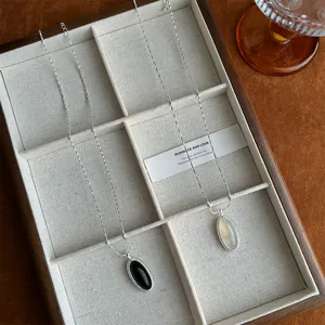 Detailed view of elegant black and white agate necklaces inside a wooden jewelry tray