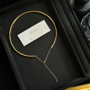 Gargantilla minimalista de metal dorado con cadena ajustable en un estuche negro