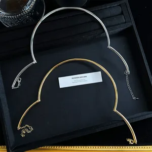 Vista detallada de collares choker metálicos ajustables en oro y plata en estuche.