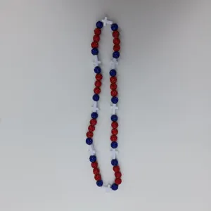 Detailed view of red and blue rhinestone bead necklace featuring white cross charms, close-up.