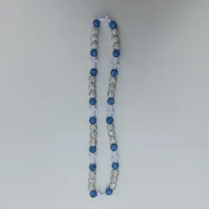 Detailed view of blue and white rhinestone clay beads necklace with white cross pieces.