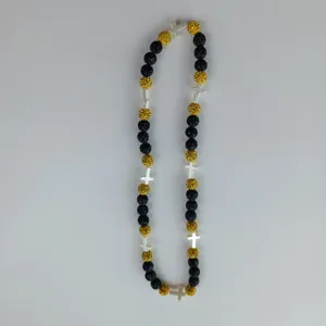 Shamballa necklace detail featuring black and gold rhinestone beads with silver cross spacers.
