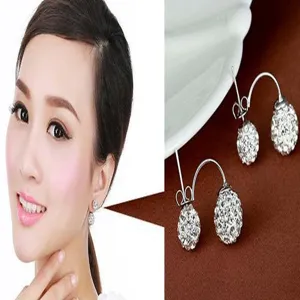 Model wearing white shamballa crystal ball earrings with macro product detail shot