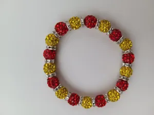 Closeup detail shot of red and yellow rhinestone clay ball shamballa stretch bracelet.