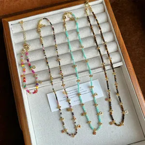 Vista detallada de collares y pulsera de piedra natural con tréboles en un joyero.
