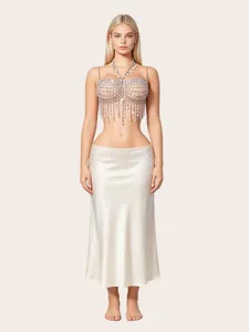 Vista dettagliata di una catena per il corpo in strass e gonna di satin indossata.