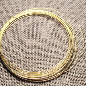 Close-up macro view of a high-quality 14k gold filled wire coil for DIY jewelry making.
