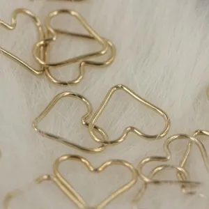 Golden heart-shaped jump rings detail shot, ideal for DIY jewelry making and craft projects.