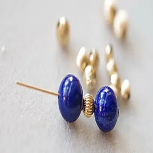 Detailed macro shot of deep blue gemstone beads and gold-filled copper spacer jewelry components.