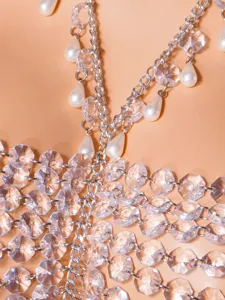 Dettaglio catena corpo con perle di cristallo, design in metallo con frange di perle finissime.