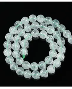 Primo piano di perle tonde in fluorite verde chiaro traslucida per la creazione di gioielli