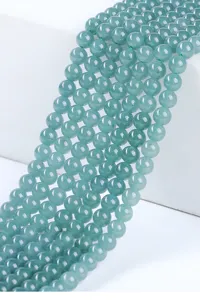 Vista macro detallada de cuentas de jadeíta azul agua natural para la creación de joyas.