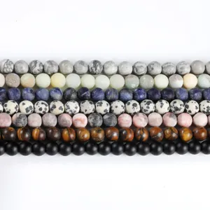 Assorted matte natural stone round beads organized in rows for DIY jewelry making.