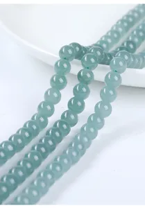 Detalle macro de cuentas de jadeíta natural agua-azul premium para joyería de bricolaje.