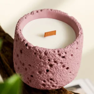 Pink textured concrete jar scented candle with wooden wick, soy wax aroma for bedroom decor.