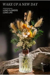Detalle del elegante difusor de aromas con botella de vidrio grabado y arreglo floral seco.