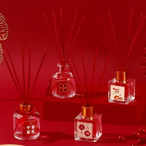 Festive New Year aroma diffuser set with red reeds and glass bottles for home decor.