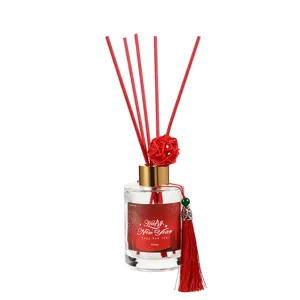 Festive red New Year aroma diffuser set with glass bottle, red reeds and tassel.