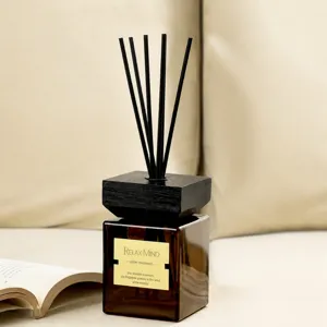 Premium amber glass reed diffuser with wooden cap for home decor and hotel room aroma diffusion.