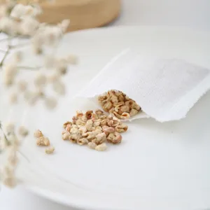 Close-up of white sachet bag with natural plant granules, showcasing detailed texture and fresh aroma.