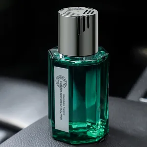 Désodorisant de voiture vert gemme en flacon en verre hexagonal chic avec un bouchon argenté.