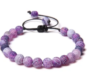 Gros plan détaillé du bracelet de perles en cristal d'agate craquelée violette et cordon.