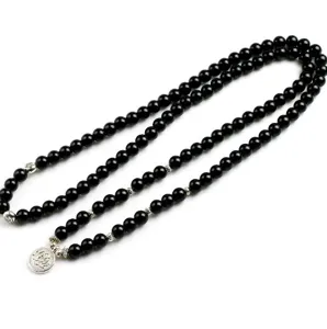 Details van de 108 zwarte kralen boeddhistische ketting met zilveren lotus hanger.