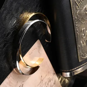 Detailed view of polished gold and silver stainless steel minimalist open cuff bracelets