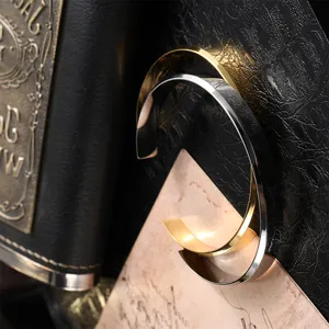 Close-up of gold and silver stainless steel open cuff bracelets with a polished finish