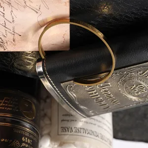 Detailed macro view of minimalist gold stainless steel open cuff bracelet on a vintage background
