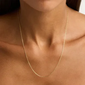 Gros plan d'un collier chaîne minimaliste en acier inoxydable doré porté au cou