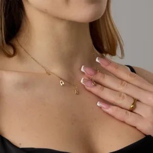 Primo piano di una collana in acciaio inossidabile dorato con ciondoli a lettera