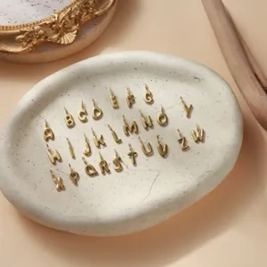 Vista dettagliata dei ciondoli in acciaio inossidabile dorato con lettere bolla A-Z DIY.