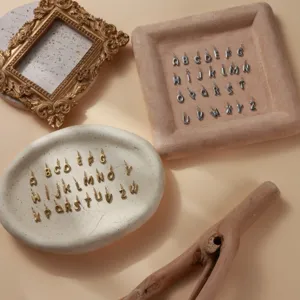Detailed view of gold and silver bubble alphabet pendants for DIY jewelry design